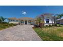 Charming single-story home featuring a tile roof, arched entryway, paver driveway, and well-maintained landscaping at 8851 Fallen Oak Dr, Davenport, FL 33896