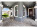 Inviting front porch with brick pavers, arched entrance, and bench seating at 1003 Nathan Ridge Rd, Clermont, FL 34715