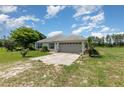 Charming single story home with a two car garage, neutral paint, and long drive at 10453 Old Studio Rd, Clermont, FL 34711