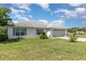 Charming single story home with a two car garage, neutral paint, and green lawn at 10453 Old Studio Rd, Clermont, FL 34711