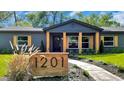 Charming home featuring a decorative wooden address sign, black trim and stylish craftsman columns at 1201 Manchester Rd, Maitland, FL 32751