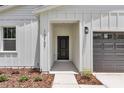 Modern home featuring a welcoming front entryway and dark-colored garage door at 13101 Sw 85 Pl, Dunnellon, FL 34432