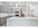 Modern kitchen with stainless steel appliances, quartz countertops, and gray cabinets at 13163 Sw 70Th Ct, Ocala, FL 34473