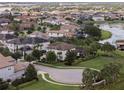 An aerial view of a residential community featuring well-maintained lawns, lake views, and many homes with solar panels at 14285 United Colonies Dr, Winter Garden, FL 34787