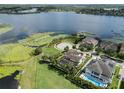 A picturesque view of homes in a lakeside community with lush landscaping, situated on a large, grassy field at 14285 United Colonies Dr, Winter Garden, FL 34787