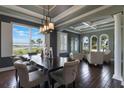 Elegant dining room featuring a dark wood table, decorative lighting, and a scenic window view with lots of natural light at 14285 United Colonies Dr, Winter Garden, FL 34787