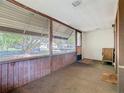 Enclosed front porch features wood paneling, multiple windows, and views of the neighborhood at 1511 New York Ave, St Cloud, FL 34769