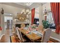 Elegant dining room with a chandelier, designer furniture and a glimpse of the adjacent living area at 162 Seville Chase Dr, Winter Springs, FL 32708