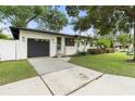 Attractive single Gathering home with black garage door, beautiful palms, and lush front lawn at 1701 Canton Street, Orlando, FL 32803