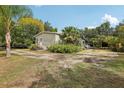 Side view of charming home with mature landscaping, porch, and concrete parking pad at 2229 N 6Th St, Orlando, FL 32820