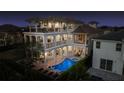 Luxury home with a multi-tiered balcony overlooking a private pool, spa, and outdoor dining area at 304 Muirfield Loop, Reunion, FL 34747