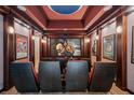 Luxurious home theater with comfortable seating, movie posters, and a large projection screen for entertainment at 304 Muirfield Loop, Reunion, FL 34747