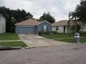 A cozy single-Gathering home with an attached two-car garage and a driveway at 3055 Leflore Ln, Orlando, FL 32833