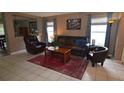 Comfortable living room featuring tile flooring, a leather sofa, and natural light at 3055 Leflore Ln, Orlando, FL 32833