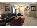 Comfortable living room featuring tile flooring, dark leather sofa, and a welcoming atmosphere at 3055 Leflore Ln, Orlando, FL 32833