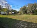 Expansive backyard with various sheds and structures surrounded by lush green trees at 306 W Palm St, Davenport, FL 33837