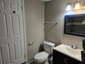 Bathroom features a modern vanity, updated fixtures, and a toilet at 306 W Palm St, Davenport, FL 33837