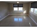 Bright bedroom features tiled floors, a ceiling fan and two windows for natural light at 306 W Palm St, Davenport, FL 33837