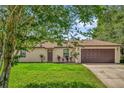 Inviting single-story home featuring a manicured lawn and an attached garage at 3685 Sunday Dr, Deltona, FL 32738