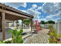 Landscaped backyard with covered pergola and paved pathway at 372 Willet St, Haines City, FL 33844