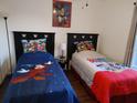 Charming bedroom featuring two twin beds with colorful, kid-friendly decor and artwork at 4031 Calabria Avenue, Davenport, FL 33897