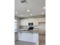 Modern kitchen featuring white cabinets, subway tile backsplash, and stainless steel appliances at 4062 Serene Water Ave, Eustis, FL 32736