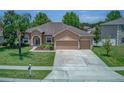 Spacious home with three car garage, well-manicured lawn, and mature palm tree at 420 Tulipwood Ln, Chuluota, FL 32766