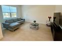 Modern living room featuring a plush grey couch and tile flooring at 5054 Tibet Ct, St Cloud, FL 34772
