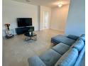 Stylish living room features a modern couch, TV, and neutral tile floors at 5054 Tibet Ct, St Cloud, FL 34772