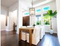 Bright dining room with modern light fixture, surrounded by large windows and dark wood flooring at 7065 Branch Court, St Cloud, FL 34771