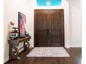 Elegant entryway showcases a stylish console table, complemented by a decorative rug and dark wood double doors at 7065 Branch Court, St Cloud, FL 34771