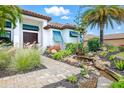 Charming home featuring a beautifully landscaped front yard with a stone walkway and a tranquil water feature at 7065 Branch Court, St Cloud, FL 34771