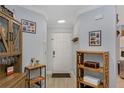 Bright foyer with tiled flooring, decorative shelving, coat hooks, and a white entry door at 7858 Sugar View Ct # 7858, Orlando, FL 32819