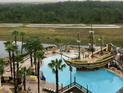 Aerial view of a pirate-themed pool area at a resort with lounge chairs and palm trees at 8125 Resort Village Dr # 5808, Orlando, FL 32821