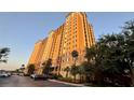 A multi-story building with balconies and parking space, surrounded by lush greenery at 8125 Resort Village Dr # 5808, Orlando, FL 32821
