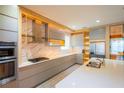 Modern kitchen with sleek cabinets, stainless steel appliances, marble backsplash, and quartz countertops at 8137 Pond Apple Dr, Winter Garden, FL 34787