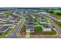 Aerial view of a residential neighborhood with modern homes, green lawns, and a scenic pond at 979 Sun Burst Rd, Winter Haven, FL 33880