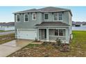 Two-story home featuring a gray exterior, a two-car garage, and a covered front porch at 979 Sun Burst Rd, Winter Haven, FL 33880