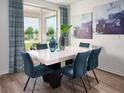 Elegant dining area features a marble table, blue upholstered chairs, and sliding glass doors with backyard views at 1106 Cumberland Trail Dr, Lake Hamilton, FL 33851