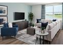 Inviting living room boasts a comfortable sofa, blue accents, large windows with lake view, and contemporary decor at 1106 Cumberland Trail Dr, Lake Hamilton, FL 33851