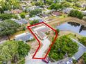 Aerial shot of a single-Gathering home featuring a pond, a long driveway, and mature landscaping at 117 Clowson Ct, Ocoee, FL 34761