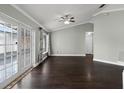 Spacious living room with hardwood floors, ceiling fan, and French doors leading to a sunroom at 117 Clowson Ct, Ocoee, FL 34761