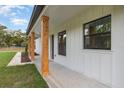 Inviting front porch featuring stylish wood posts and modern black windows at 12460 Sw 48 Lane Rd, Ocala, FL 34481