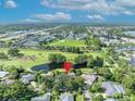 An aerial view of a lovely home near a golf course with lush greenery and a pond in a serene setting at 1387 Sawgrass Court, Winter Park, FL 32792