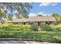 Inviting single-story home with lush landscaping in front of the house and well-maintained bushes at 1387 Sawgrass Court, Winter Park, FL 32792