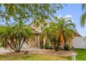 Well maintained, single Gathering home with mature palm trees and decorative rock in the front yard at 14617 Keelford Way, Orlando, FL 32824