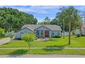 Beautiful one-story home with a green lawn and mature landscaping at 14651 Pine Cone Trl, Clermont, FL 34711