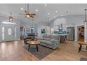 Open-concept living room features a large sofa, kitchen with stainless steel appliances, and dining area at 14651 Pine Cone Trl, Clermont, FL 34711