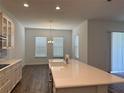 Bright kitchen features a long center island with white countertops, cabinets, and modern appliances at 15161 Lake Bessie Loop, Winter Garden, FL 34787