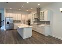 Spacious kitchen with an island, stainless steel appliances, modern lighting, and updated cabinets at 15161 Lake Bessie Loop, Winter Garden, FL 34787